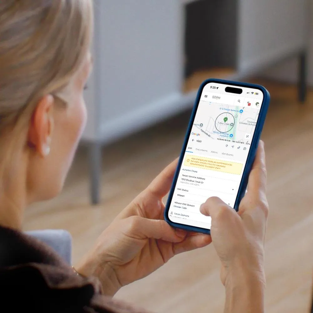 A home care professional reviewing a GPS-verified visit in the GEOH mobile app on her phone.